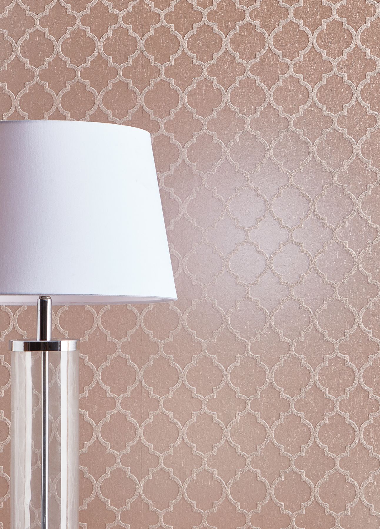 Eine Rosenholz farbene Glasperlentapete mit Trellis-Muster, davor eine Tischleuchte mit weißem Schirm