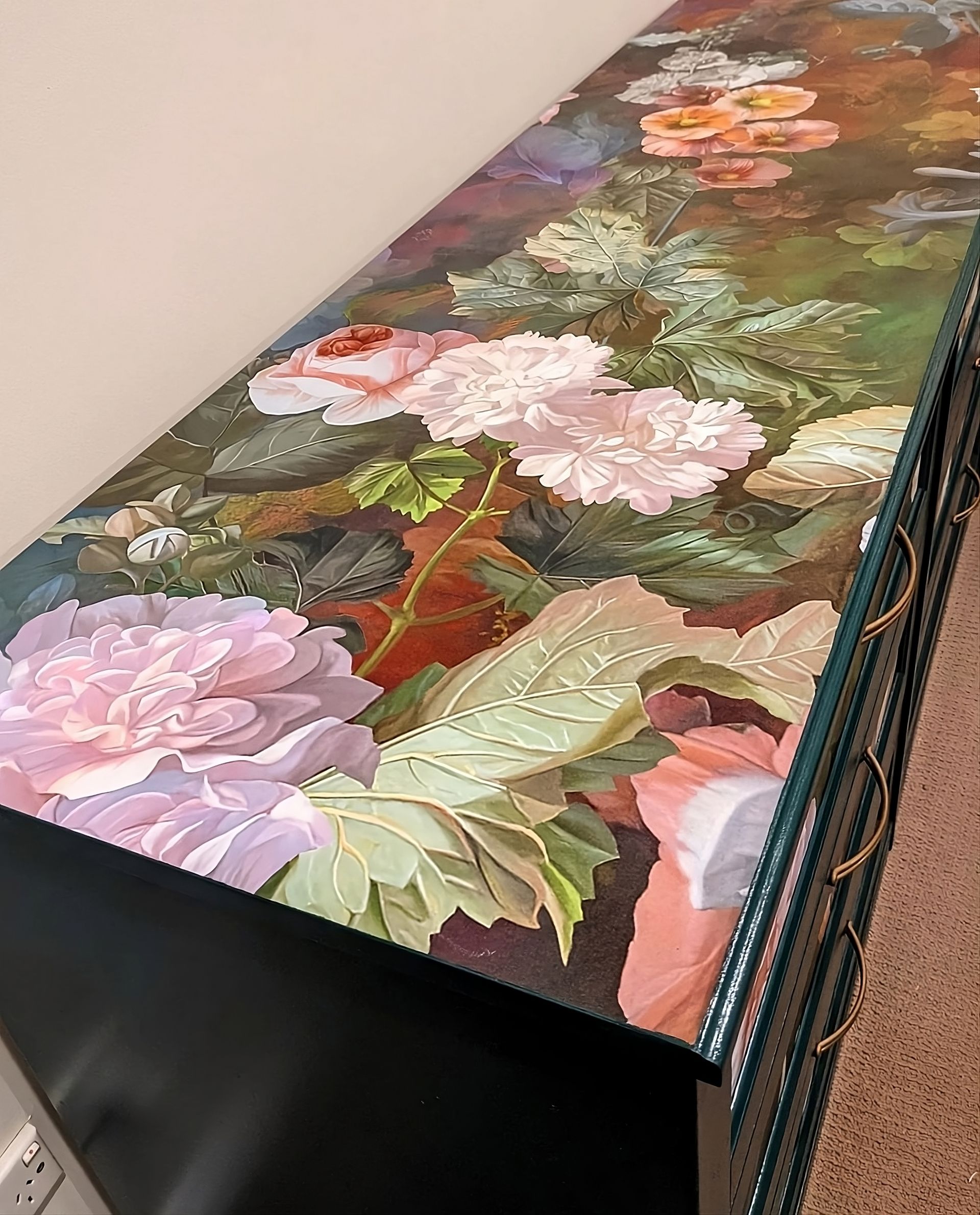 Kommode mit floraler Tapete auf der Oberfläche, die eine luxuriöse und künstlerische Möbelgestaltung schafft.