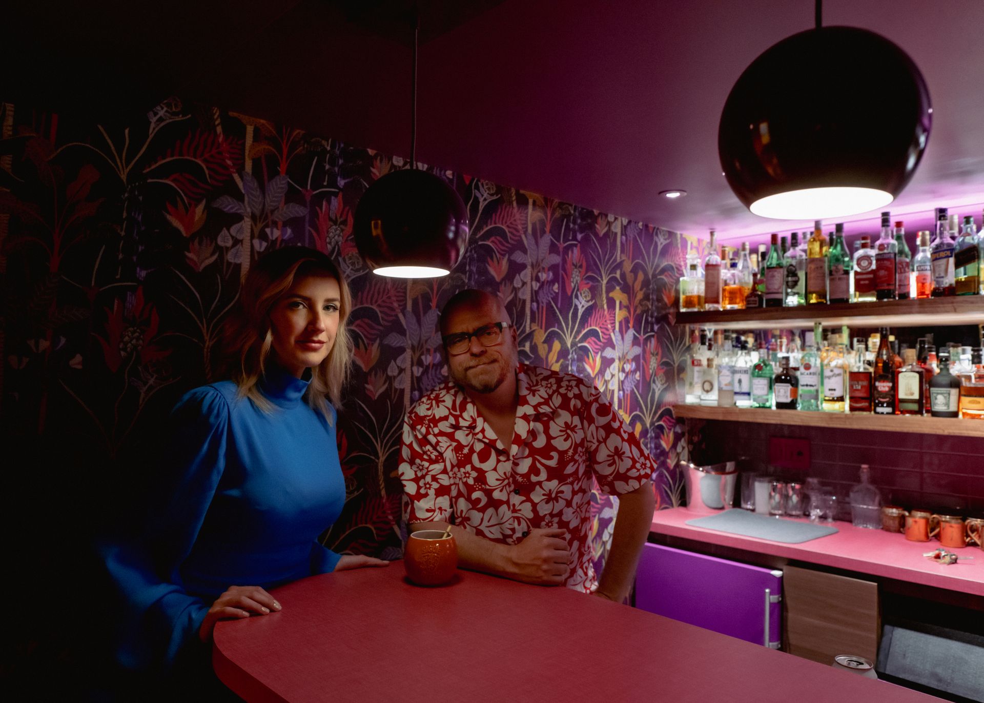 Chroma House Bar mit Speakeasy-Atmosphäre, hervorgehoben durch die violette Tropical-Dream-Tapete und passendes Vintage-Dekor.